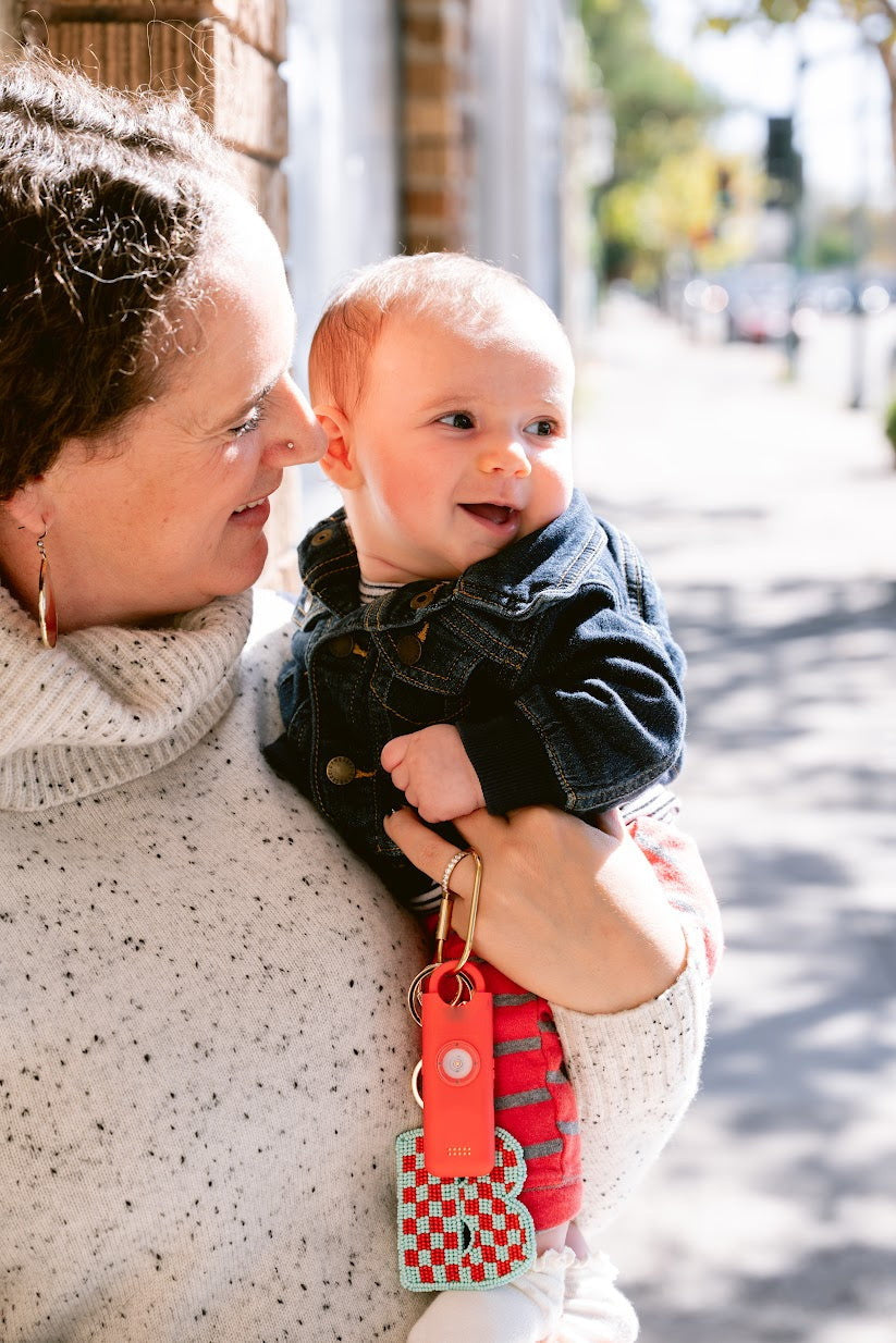 Mère portant son bébé, alarme Roxy accrochée à son sac