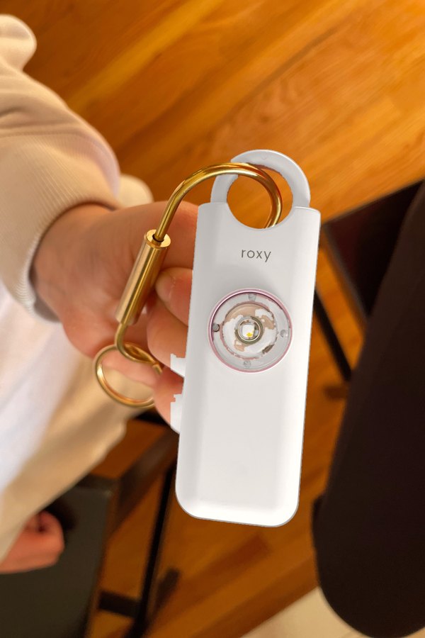Cliente tenant son alarme Roxy blanche par son mousqueton